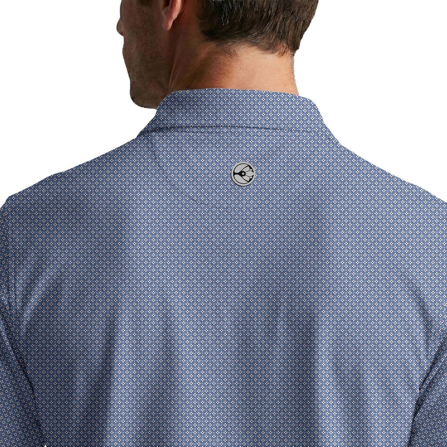 Close-up of a blue patterned shirt with a brand logo on the collar against a white background
